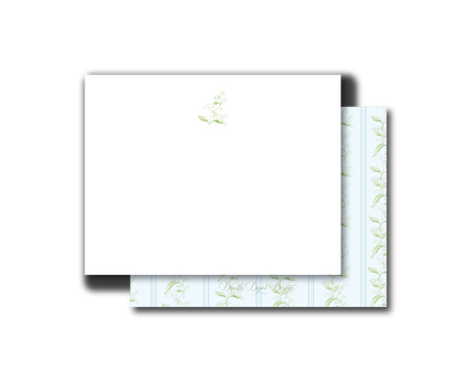 A stack of white stationery cards or envelopes with a delicate pale green floral pattern visible along the edges, shown on a plain white background.