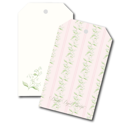 Two decorative gift tags with a lily of the valley floral design. One tag is plain cream with a small green floral print in the lower left and a hanging hole at the top.