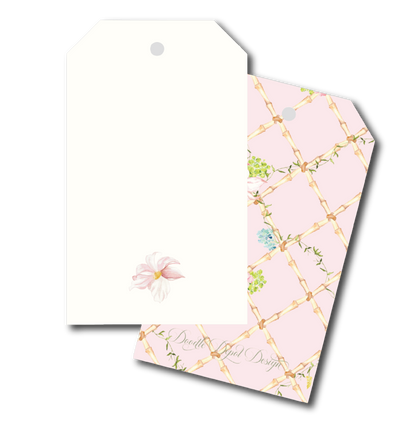 Two decorative gift tags with hanging holes, shown on a white background. The front tag is plain white with a small pale pink flower near the bottom.